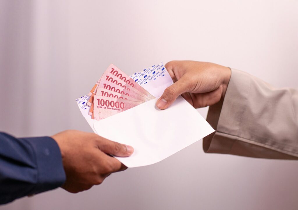 Money is being handed over between two people.